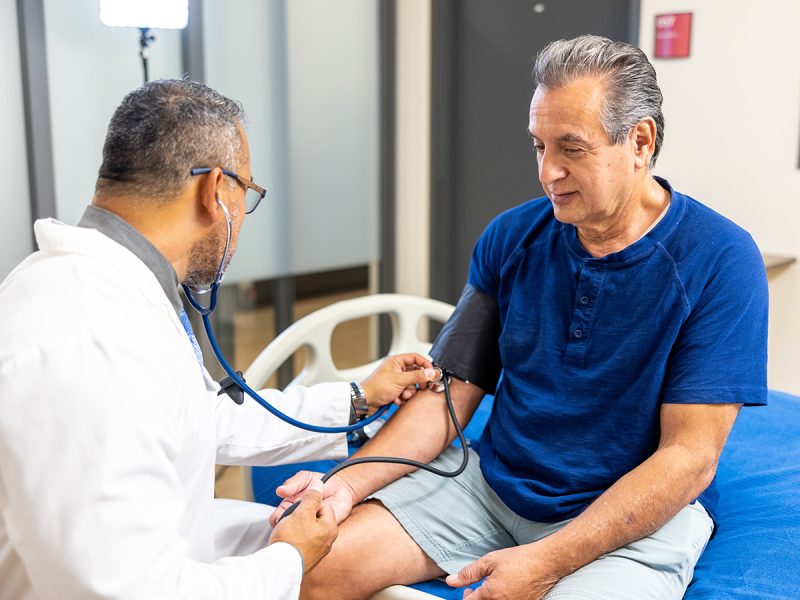 Primary care physician checking patient's blood pressure