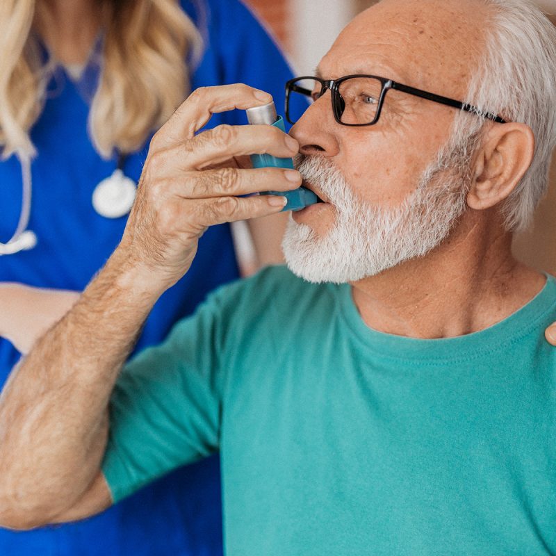 Senior patient using an asthma inhaler