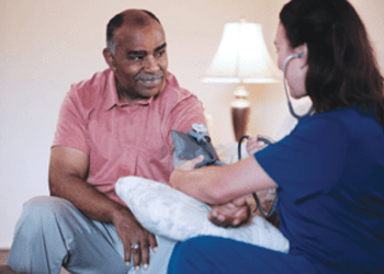 Nurse checking elderly man's blood pressure