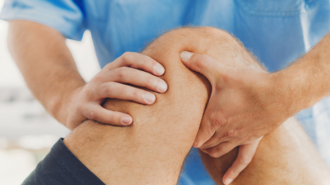 Physician or physical therapist working with a patient's knee