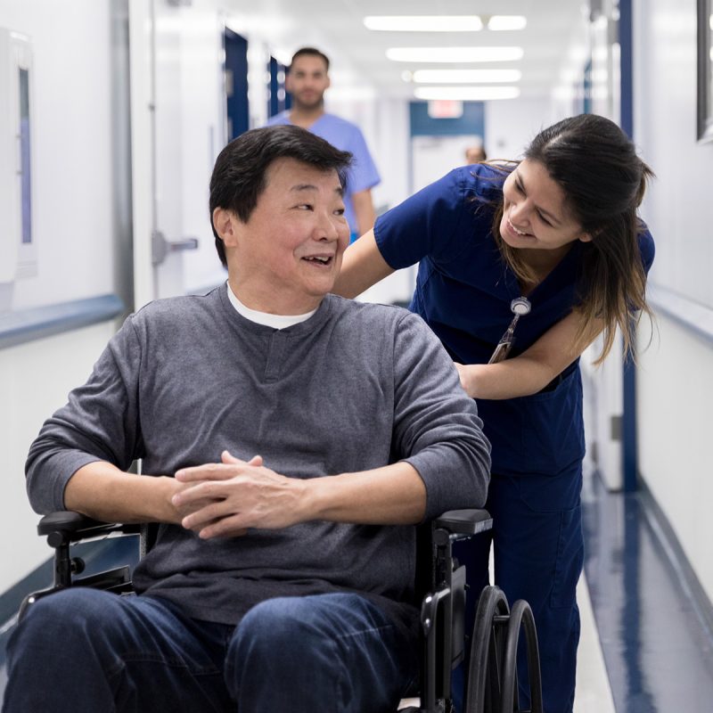 Nurse pushing a patient in a wheelchair